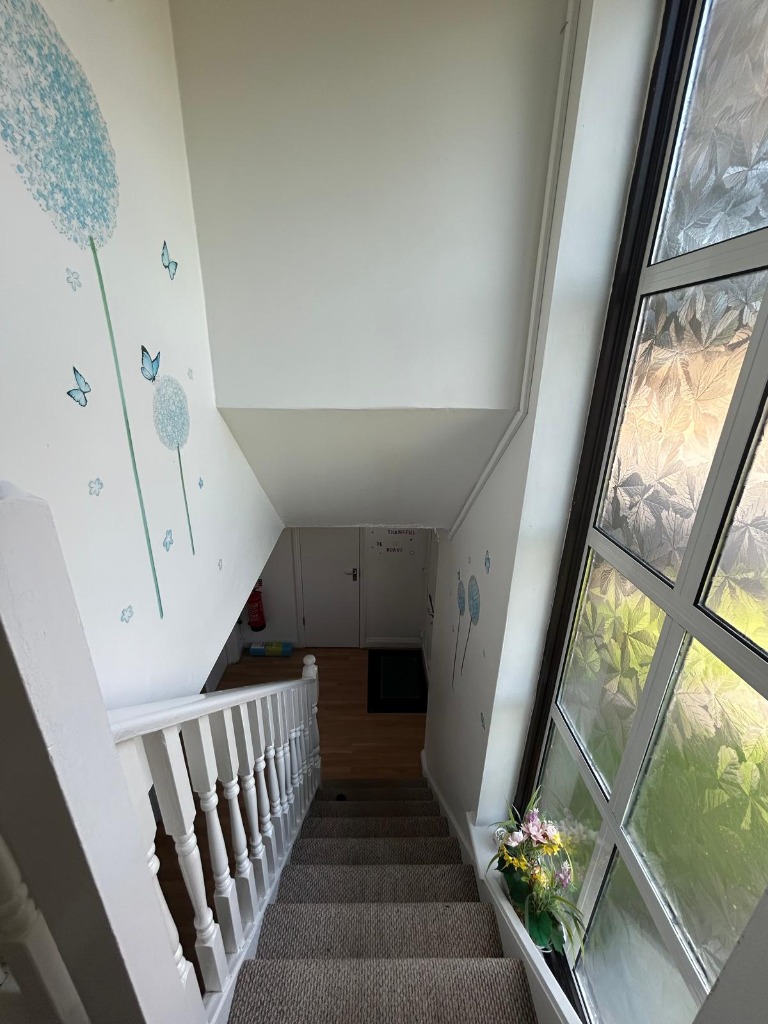Hallway and staircase with uplifting wall decals and natural window light